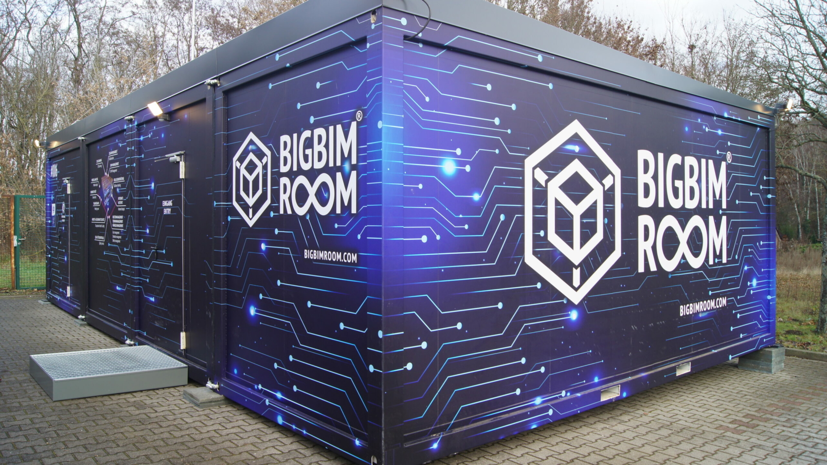 Außenansicht des BIGBIMROOM: Ein Bürocontainer in unterschiedlichen Blautönen und weißen Vernetzungslinien. Der Schriftzug BIGBIMROOM ist in großen weißen Buchstaben zu sehen, das Logo ist ein Würfel in einer Box
